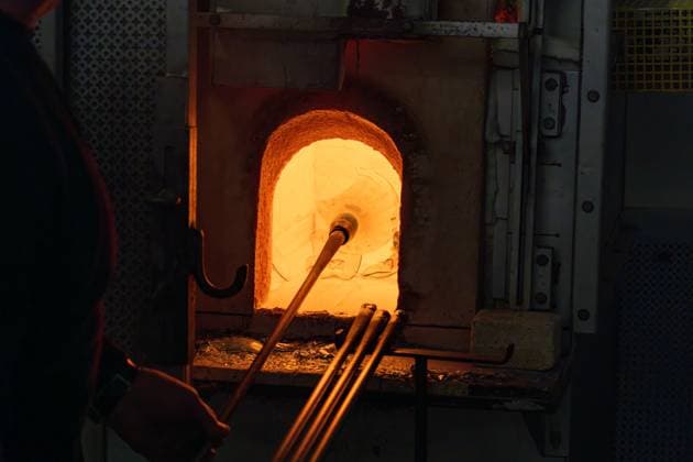 The glassblower breaks the completed pitcher in the furnace in a glassblowing demonstration in Venice, Italy. The glass remelts for use in the next demonstration. Venice Venezia Italy Copyright: xJonxG.xFullerx xVWPicsx 5737-JGF-GlassBlowing-Venice-IT