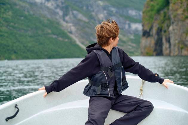 Person enjoying a boat ride on a calm mountain lake with arms outstretched, Geirangerfjord, Norway bola05836 Copyright: xConnectxImagesx ,model released