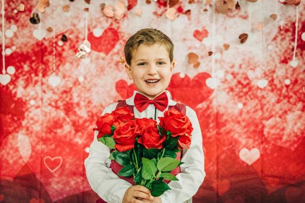 Creative Highlights Symbolbilder 783449156 Smiling boy in bow tie holds roses against Valentine s heart backdrop North Andover, Massachusetts, United States CR_FKNH241202-1584300-01 ,model released, Symbolfoto