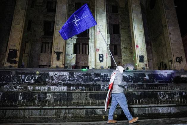 Bilder des Jahres 2024, News 12 Dezember News Themen der Woche KW49 News Bilder des Tages GEORGIA, TBILISI - DECEMBER 4, 2024: A man carries a NATO flag during a rally outside the parliament building as mass protests come in response to Georgia s decision to suspend talks on its bid to join the European Union until 2028. Alexander Patrin TASS  76539235