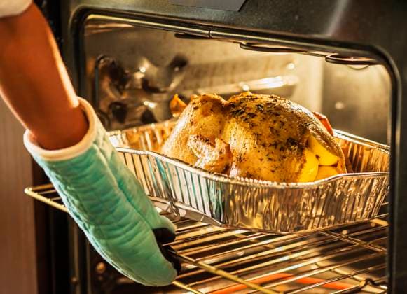 Woman checking turkey in oven , 20.01.2015, model released, TTBB_ti03007113.jpg, Turkey,Reaching,Oven Mitt,Horizontal,Indoors,Day,Part Of,Human Arm,Human Hand,25-29 Years,One Young Woman Only,One Person,At Home,House Interior,Domestic Kitchen,Food Preparation,Thanksgiving,Tradition,Holiday,Festive,Dinner,Food,Lemon,Preparation,Oven,Stove,Hand,Taking Out,Finished,Cooked,Meal,Usa,Florida,Jupiter Copyright: xDanielxGrillx