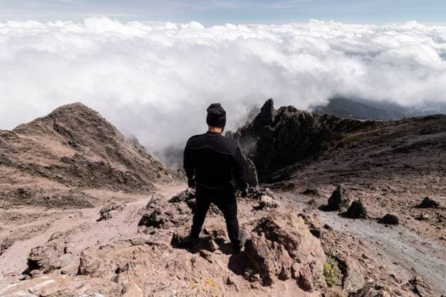 Creative Highlights Symbolbilder 783449156 A person stands on La Malinche s rocky summit, gazing at a sea of clouds This image captures the majestic scenery and adventurous spirit of this Mexican volcano Model Released EduardoGavira_ID25187_728547_020 Copyright: xEduardoxGavirax
