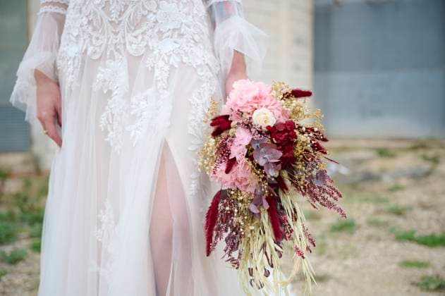 Creative Highlights Symbolbilder 783449156 A bride elegantly holds a bouquet featuring pink and burgundy blooms, complemented by a beautifully detailed lace gown The feminine floral design exudes romance and charm Model Released GermanLinares_ID25222_729493_008 Copyright: xGermanxLinaresx RECORD DATE NOT STATED