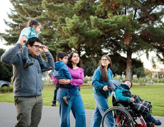 Latin family spends quality time in a park Parents carry their children on their shoulders and arms, while the eldest daughter pushes her brother s wheelchair, Model Released Padnob_ID22345_652594_034 Copyright: xPadnobx RECORD DATE NOT STATED