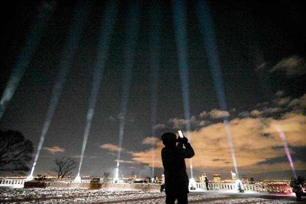 December 6, 2024, Montreal, Pq, Canada: A person takes photographs of beams of light projected into the sky during a vigil to honour the victims of the 1989 Polytechnique massacre in Montreal, Friday, December 6, 2024. Today marks the 35th anniversary of the shooting rampage that left 14 women dead. Montreal Canada  - ZUMAc35_ 20241206_zaf_c35_079 Copyright: xGrahamxHughesx