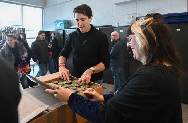 December 7, 2024, Montreal, Pq, Canada: Prime Minister Justin Trudeau helps a volunteer unpack a box of canned food items which will be used to make Christmas baskets during a community event in Montreal, Saturday, December 7, 2024. Montreal Canada  - ZUMAc35_ 20241207_zaf_c35_025 Copyright: xGrahamxHughesx