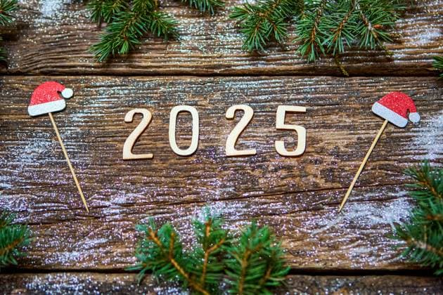 7 December 2024: The year 2025 made of wood lies on a rustic wooden table, surrounded by Christmas decorations such as dried oranges, anise stars, fir branches and snow *** Die Jahreszahl 2025 aus Holz liegt auf einem rustikalen Holztisch, umgeben von weihnachtlicher Dekoration wie getrockneten Orangen, Anissternen, Tannenzweigen und Schnee