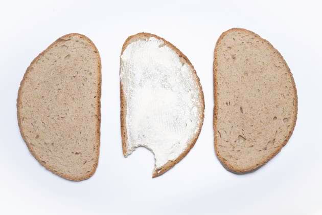 Brot mit Biss und Butteraufstrich , Deutschland, 12.12.2024, Drei Brotscheiben, eine davon mit Butter und angebissen, auf weißem Hintergrund. Ideal für gesunde Snacks und Ernährungsinspiration. *** Bread with bite and butter spread , Germany, 12 12 2024, Three slices of bread, one with butter and bite, on a white background Ideal for healthy snacks and nutritional inspiration