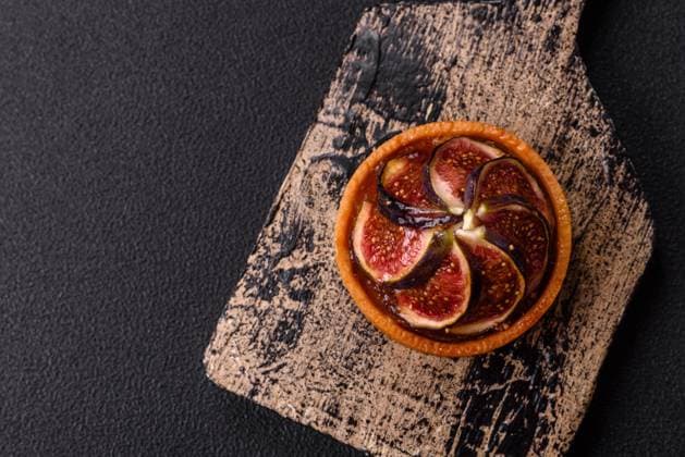 Süße Torte mit Feigen, Käsecreme und Pekannüssen Sweet tart with figs, cheese cream and pecans on a dark concrete background Copyright: xZoonar.com TetianaxChernykovax 22335026
