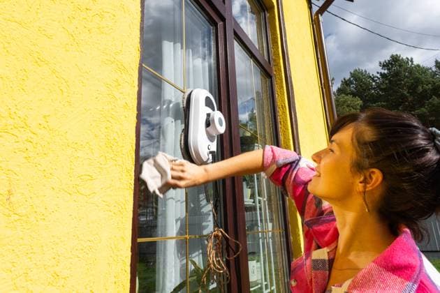 IMAGO Creative, Frühling, Frühjahrsputz Eine Frau startet einen Fensterputzroboter des Hauses mit gelber Fassade. Haushaltsroboter, Haushaltshilfe, Reinigungsservice A woman launches a window cleaner robot of the house outside with a yellow facade. Household robotics, household assistant, cleaning servise ,model released, Symbolfoto Copyright: xZoonar.com OlgaxSimonovax 22345489 ,model released, Symbolfoto ,property released