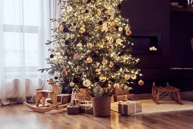 Christmas decor in cosy, domestic living room with christmas tree with lighting strings, balls, wooden rocking chair, gifts wrapped in craft paper, sledge. Background with copy space Christmas decor in cosy, domestic living room with christmas tree with lighting strings, balls, wooden rocking chair, gifts wrapped in craft paper, sledge. Background with copy space. Copyright: xZoonar.com DARYAxKOMAROVAx 22418367