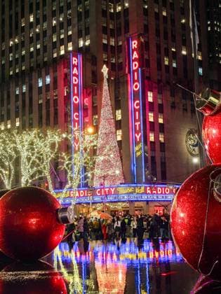 December 17, 2024, New York, New York, USA: The Radio City Music Hall decked out with Christmas tree reflects in a fountain pool with large life size red ornaments along 5th Avenue in NYC. New York USA - ZUMAo116 20241217_znp_o116_034 Copyright: xBiancaxOterox