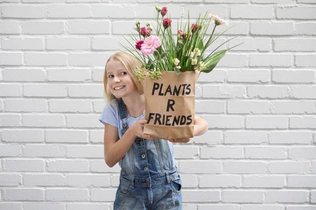 Creative Highlights Symbolbilder Portrait of smiling girl holding paper bag with flowers model released, Symbolfoto, PSTF00187