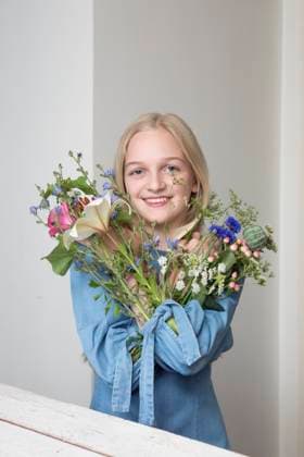 Creative Highlights Symbolbilder Portrait of smiling blond girl with bunches of flowers in sleeves of her dress model released, Symbolfoto, PSTF00217