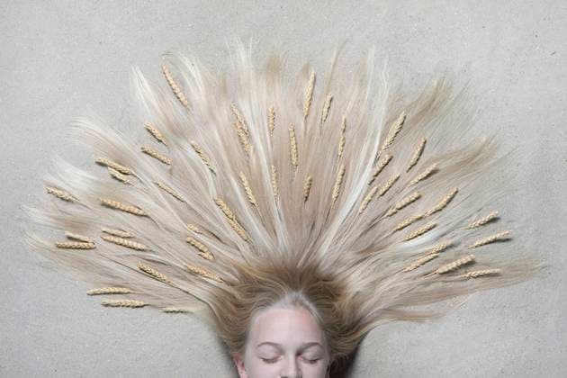 Creative Highlights Symbolbilder Portrait of girl lying on floor with eyes closed and ears of wheat on hair model released, Symbolfoto, PSTF00222