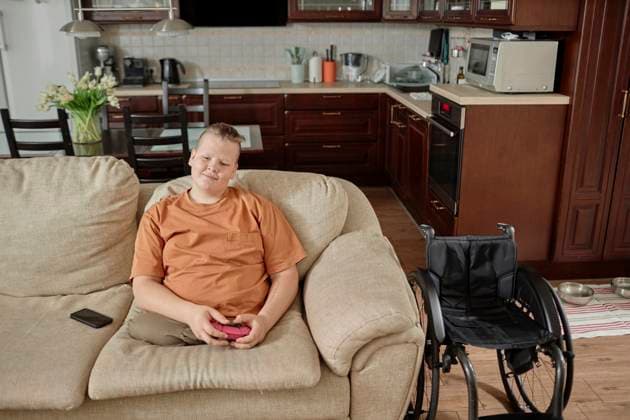 IMAGO Creative, Lifestyle, Gaming Boy with disability playing video game at home model released, Symbolfoto property released, KPEF00861