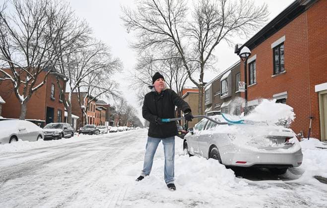 December 24, 2024, Montreal, Pq, Canada: A man clears snow from around his car following a snowstorm in Montreal, Tuesday, December 24, 2024. Montreal Canada  - ZUMAc35_ 20241224_zaf_c35_002 Copyright: xGrahamxHughesx