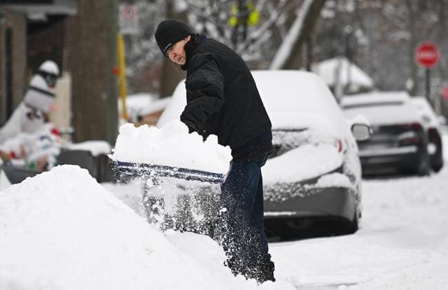 December 24, 2024, Montreal, Pq, Canada: A person clears snow from around a car following a snowstorm in Montreal, Tuesday, December 24, 2024. Montreal Canada  - ZUMAc35_ 20241224_zaf_c35_003 Copyright: xGrahamxHughesx