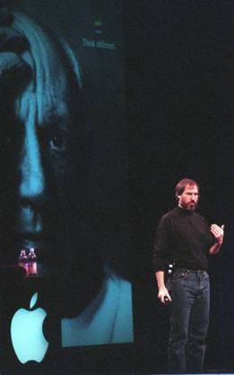 Steve Jobs In this January 6, 1998 file photograph, Steve Jobs, interim CEO of Apple, kicked-off the annual Macworld Expo at the Marriott in San Francisco as an image of Pablo Picasso from the Apple Think Different ads looms in the background. (Richard Koci Hernandez San Jose Mercury News MCT) San Francisco CA USA EDITORIAL USE ONLY Copyright: xx 1112285 RichardxKocixHernandezx krtphotoslive513405