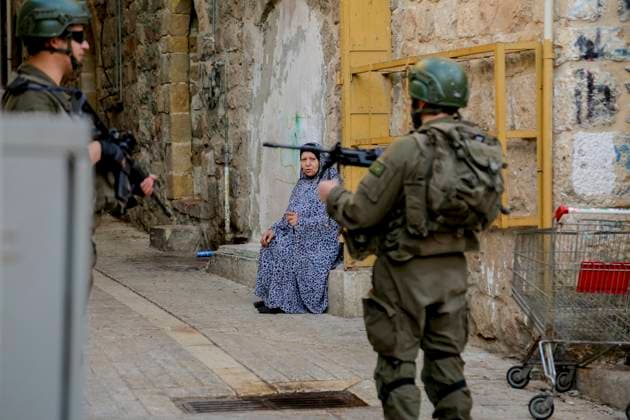 Bilder des Jahres 2024, News 12 Dezember News Themen der Woche KW52 News Bilder des Tages Israeli Security Measures in Hebron Old City A Palestinian woman talks to Israeli army soldiers standing guard as Israeli Jewish settlers tour the old market in the city of Hebron in the occupied West Bank on December 28, 2024. Hebron West Bank Palestinian territories Copyright: xMosabxShawerx