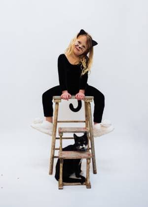 Creative Highlights Symbolbilder Young girl dressed as black cat with her cat Marblehead, Massachusetts, United States R_NYHM250105-1618897-01 ,model released, Symbolfoto