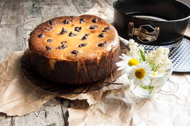 Cheesecake on an old table with a bouquet of daisies and a form for baking. Near wrapping paper. Retro style. From the series Still Life with cheesecake , 46003260.jpg, celebrations, dessert, chocolate, food, sweet, flower, cake, cheesecake, cheese, baking, decoration, table, gourmet, single, eating, plate, temptation, brown, traditional, biscuit, easter, cherry, refreshment, pastry, white, dishware, homemade, close-up, colors, cream, freshness, portion, tablecloth, nobody, yellow, life, breakfast, spoon, wood, part, amomile, glass cup, bouquet, packaging paper, still life, retro, horizontal RECORD DATE NOT STATED