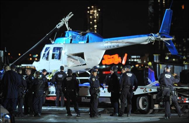 Manhattan chopper down October 4, 2011, New York, New York, USA: Just after 3PM, a helicopter with four British tourists and the pilot went down into East River by the 34th Street heliport. Four people were pulled out, one female was DOA ( dead on arrival ) and pulled out of the chopper which sank in the East River about 90 minutes later. The cause of the accident is unknown. Manhattan, New York, Tuesday, October 4th 2011. Chopper lifted by crane onto a flat-bed truck.. Credit: Paul Martinka Polaris New York USA  Copyright: xPaulxMartinkax