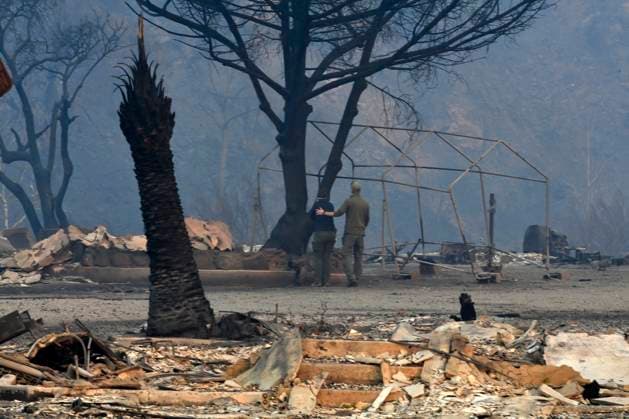 News Themen der Woche KW02 One of the thousands of structures destroyed by four Southern California wildfires in Los Angeles County is seen along the Pacific Coast Highway in Los Angeles on Thursday, January 9, 2025. A woman is comforted upon seeing what s left of her home on the PCH.  LAP2025010901 JIMxRUYMEN