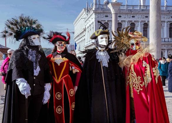 Colorful masquerade group in vibrant venetian costumes outside h Venice, Veneto, Italy R_GVYI250112A-1626519-01 EDITORIAL USE ONLY