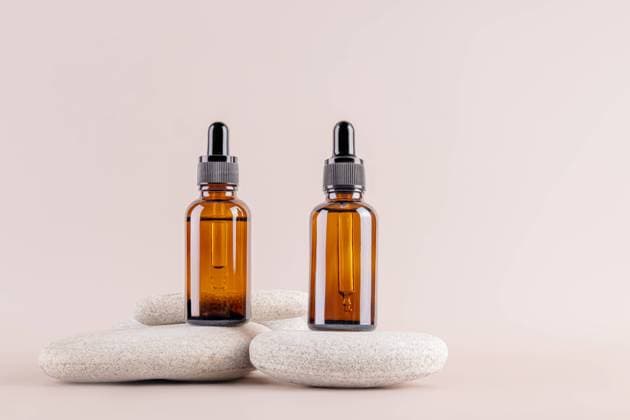 IMAGO Creative, Naturkosmetik Two amber glass dropper bottles on minimalist stones, set against a neutral background Ideal for essential oils, serums, or cosmetics packaging, embodying simplicity and elegance Model Released MarinaMos_ID25940_748913_005 Copyright: xMarinaxMosx