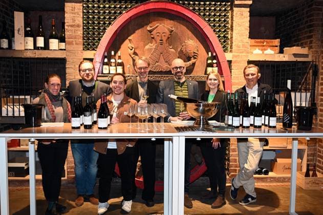 Winemakers Theresa Breuer, Maximin von Schubert, Andreas Brensing Managing Director of Kölner Weinkeller , the winemakers , Steffen Brahner, Katharina Jost and Rewe Group CEO Lionel Souque, l r, pose in the treasure chamber at the event Kölner Weinkeller was named Wine Retailer of the Year 2025 by trade magazine Weinwirtschaft