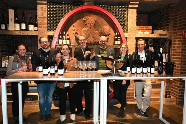 Winemakers Theresa Breuer, Maximin von Schubert, Andreas Brensing Managing Director of Kölner Weinkeller , the winemakers , Steffen Brahner, Katharina Jost and Rewe Group CEO Lionel Souque, l r, pose in the treasure chamber at the event Kölner Weinkeller was named Wine Retailer of the Year 2025 by trade magazine Weinwirtschaft