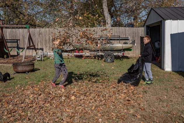 2 boys picking up leaves while one boy throws them in air Norman, Oklahoma, United States R_AOVS250119B-1601144-01 ,model released, Symbolfoto