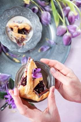 A piece of raspberry layer cake in a woman s hand Lilac wilted tulips on a pewter platter, spring still life. High quality photo , 48316390.jpg, background, flower, purple, spring, tulip, fresh, bouquet, seasonal, bunch, celebration, colorful, festive, holiday, table, white, beautiful, bloom, blossom, floral, garden, green, natural, nature, petal, plant, romantic, season, summer, arrangement, baked, bakery, bow, breakfast, bundt cake, cake, candied orange peel, confectionery, decor, decoration, delicious, dessert, easter, egg, food, homemade, march, orange, pastel, pastry, april RECORD DATE NOT STATED