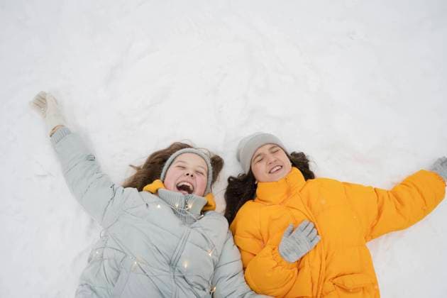 Cheerful teenage girls lying down on snow in winter forest model released, Symbolfoto, LESF00659