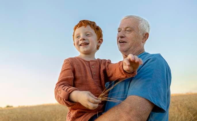 Grandfather carrying grandson in arms at agricultural field model released, Symbolfoto, MBLF00733