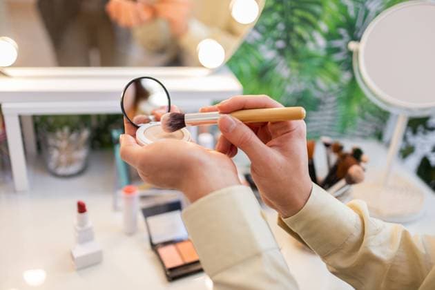 IMAGO Creative, Naturkosmetik Close-up of hands holding a makeup brush and compact powder while testing organic beauty products in an eco-friendly store The setup features natural cosmetics and sustainable design Model Released DavidMunoz_ID26067_751983_047 Copyright: xDavidxMunozx