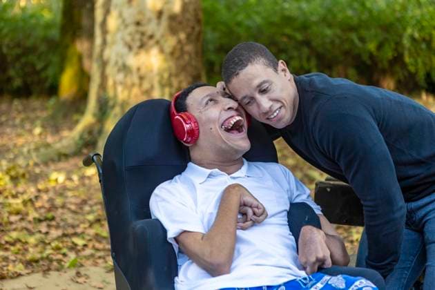 Heartwarming image of Spanish Cameroonian siblings outdoors, one in a wheelchair with cerebral palsy. Their mixed-race heritage adds a rich layer to their joyful bond. Model Released JuanAizpuru_ID26079_752143_015 Copyright: xJuanxAizpurux