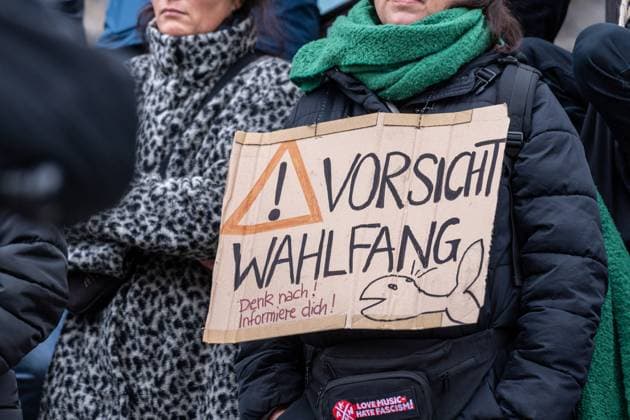 Aschaffenburg, Bavaria, Germany - January 26, 2025: Demonstration and march after knife attack against current government and political action. A demonstrator carries a sign with the inscription: Caution election catch - Think! Inform yourself!, which warns against political manipulation and election campaign strategies *** Demonstration und Marsch nach Messerattacke gegen aktuelle Regierung und politisches Handeln. Eine Demonstrantin trägt ein Schild mit der Aufschrift: Vorsicht Wahlfang Denk nach! Informiere dich!, das vor politischer Manipulation und Wahlkampfstrategien warnt