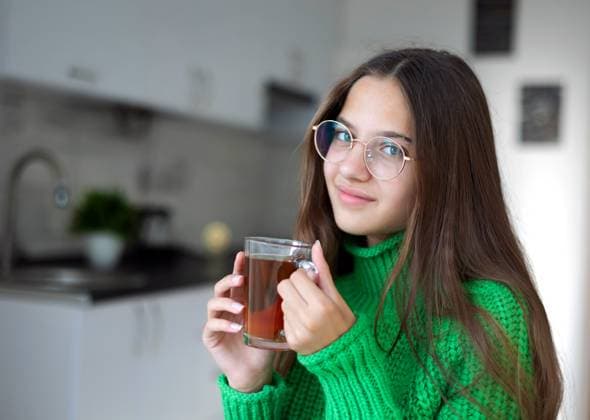 Young girl with glasses enjoying tea in the kitchen Lviv, Lviv Oblast, Ukraine R_ZSOH250124-1637935-01 ,model released, Symbolfoto