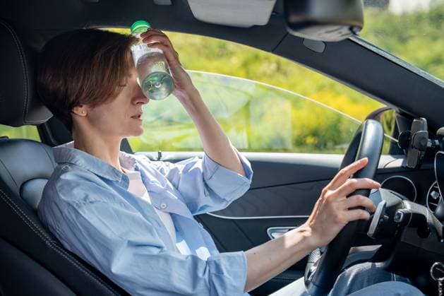 Heißes Wetter für Autofahrer. Müde von der Hitze Frau im Auto nehmen Pause Kühlung Stirn mit kalten Flasche Suffering from heat exhausted woman driver sitting in car with open window put cold bottle of water to forehead in traffic. Overheat frowned middle age female touch steering wheel with close eyes ,model released, Symbolfoto Copyright: xZoonar.com DmitriixMarchenkox 22708254 ,model released, Symbolfoto ,property released
