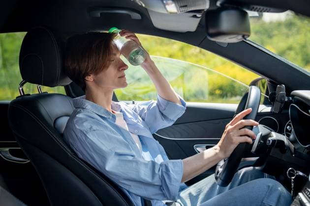 IMAGO Creative, Jahreszeit Sommer, Hitze Vor Hitze erschöpfte Frau sitzt im Auto und hält sich mit geschlossenen Augen eine kalte Flasche an die Stirn Hot weather for drivers. Tired from heat woman in car cooling forehead with cold bottle of water. Exhausted female take break in car park suffering from heat in summer city feeling dizziness pressure ,model released, Symbolfoto Copyright: xZoonar.com DmitriixMarchenkox 22708257 ,model released, Symbolfoto ,property released