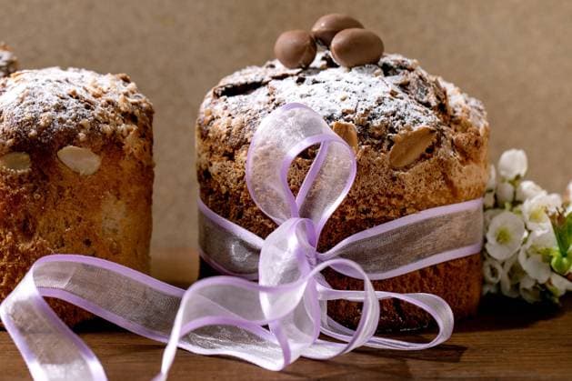 Traditioneller italienischer Oster-Panettone-Kuchen Homemade Italian traditional Easter panettone cake, decorated by chocolate eggs, pink ribbon and blossoming cherry tree flowers standing on wooden table. Traditional Easter European bake. Close up Copyright: xZoonar.com NATASHAxBREENx 22709717