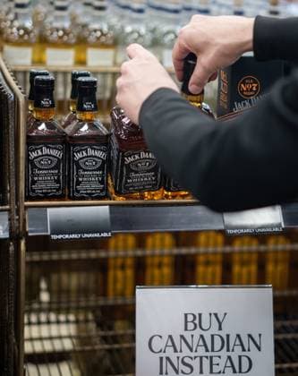 February 2, 2025, Vancouver, Bc, CANADA: A B.C. Liquor Store employee demonstrates removing bottles of American whiskey for media before a news conference in Vancouver, B.C., Sunday, Feb. 2, 2025. Vancouver CANADA  - ZUMAc35_ 20250202_zaf_c35_114 Copyright: xEthanxCairnsx