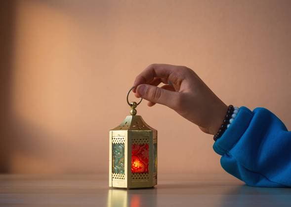 human hand holding A Ramadan lantern with colorful glass panels Cairo, Cairo Governorate, Egypt R_TNTDFU250202-1642348-01