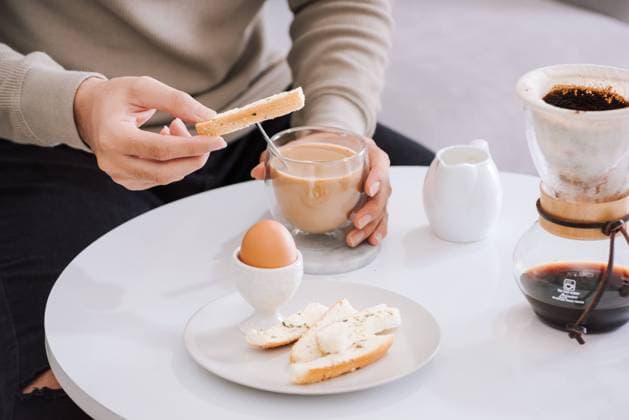 Fresh delicious breakfast with soft boiled egg, crispy toasts and cup coffee in living room , 49160976.jpg, coffee, breakfast, milk, white, cup, woman, room, living, background, lifestyle, drink, table, morning, bowl, jam, beautiful, young, person, happy, adult, food, healthy, attractive, egg, toast, drip, sofa, male, sitting RECORD DATE NOT STATED