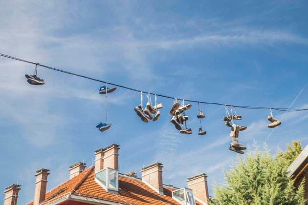 Old worn-out shoes hang from wires in slovenia. , 49235616.jpg, shoe, wire, sky, hanging, cable, sneaker, concept, electric, footwear, sport, shoelace, lace, pair, fun, old, urban, street, boot, prank, youth, dangling, city, joke, cord, power line, tied, design, lifestyle, sports shoe, tossing, roof, high, throwing, power supply, telephone line, worn, symbolism, hung, creative, humor, ideas, blue sky, clothing, tourism, travel, youth culture, slovenia, ljubljana, metelkova, violation of the law RECORD DATE NOT STATED