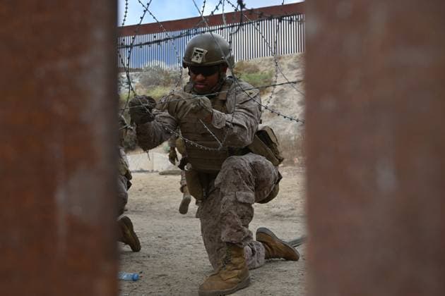February 6, 2025, Tijuana, Baja California, Mexico: A member of the US Marine Corps installing concertina wire along the US-Mexico border wall in San Diego, California, seen from Tijuana, Mexico in between the San Diego-Tijuana border fences of Colonia Libertad on Thursday, February 06, 2025. The Defense Department deployed 1,600 active-duty troops to the border during US President Donald Trumpâ€⠢s first week in office. Tijuana Mexico - ZUMAm180 20250206_zip_m180_002 Copyright: xCarlosxA.xMorenox