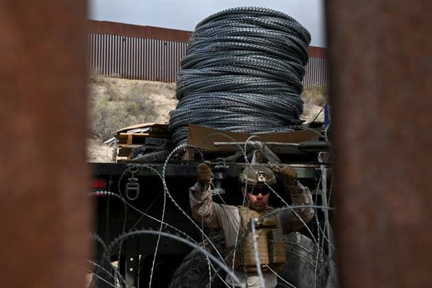 February 6, 2025, Tijuana, Baja California, Mexico: A member of the US Marine Corps installing concertina wire that will go along the US-Mexico border wall in San Diego, California, seen from Tijuana, Mexico in between the San Diego-Tijuana border fences of Colonia Libertad on Thursday, February 06, 2025. The Defense Department deployed 1,600 active-duty troops to the border during US President Donald Trumpâ€⠢s first week in office. Tijuana Mexico - ZUMAm180 20250206_zip_m180_007 Copyright: xCarlosxA.xMorenox