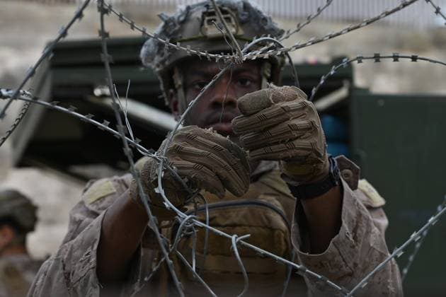 February 6, 2025, Tijuana, Baja California, Mexico: A member of the US Marine Corps installs concertina wire along the US-Mexico border wall in San Diego, California, seen from Tijuana, Mexico in between the San Diego-Tijuana border fences of Colonia Libertad on Thursday. The Defense Department deployed 1,600 active-duty troops to the border during US President Trump s first week in office. Tijuana Mexico - ZUMAm180 20250206_zip_m180_001 Copyright: xCarlosxA.xMorenox